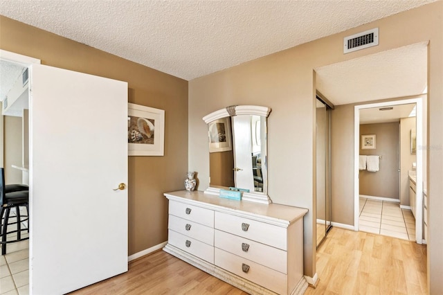 bedroom featuring light wood-type flooring and a textured ceiling