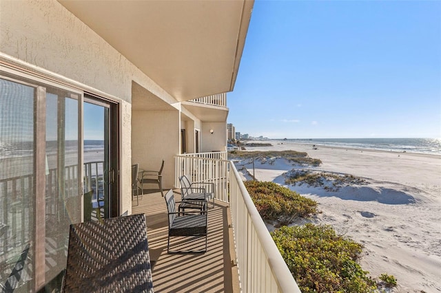 balcony featuring a water view and a view of the beach