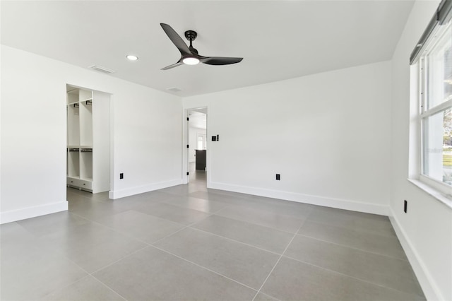 empty room with tile patterned floors and ceiling fan