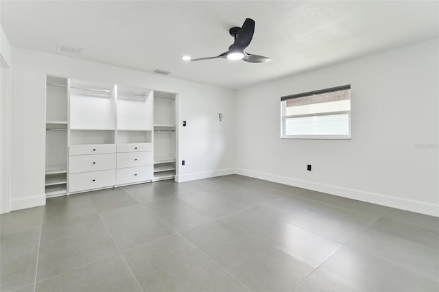 unfurnished bedroom featuring ceiling fan and dark tile patterned flooring