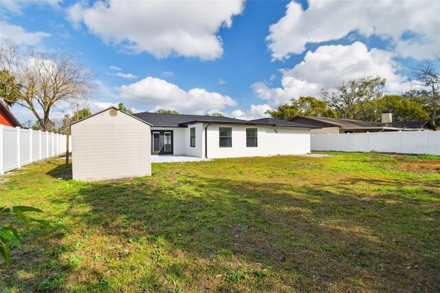 rear view of house with a yard and a patio