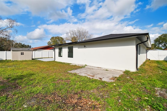 back of property featuring a shed and a lawn