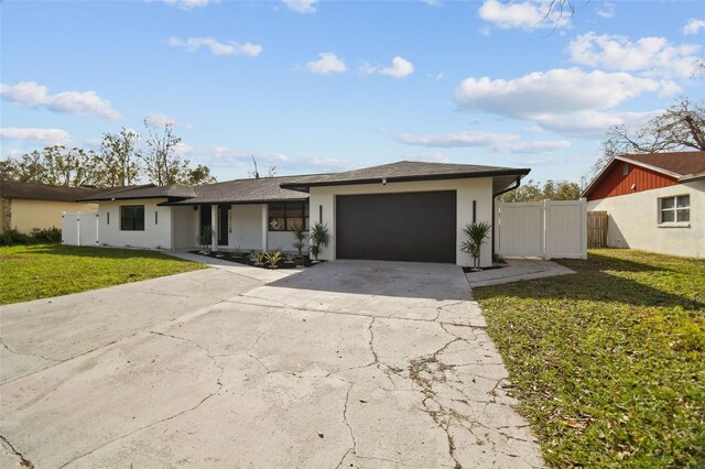 ranch-style house featuring a garage and a front lawn