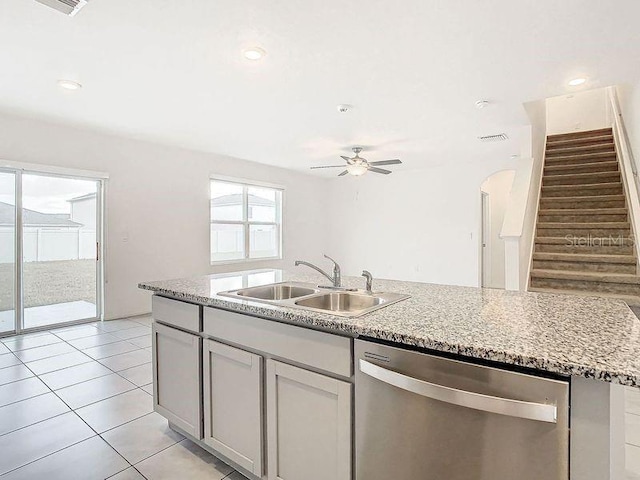 kitchen featuring ceiling fan, sink, light tile patterned floors, a center island with sink, and dishwasher