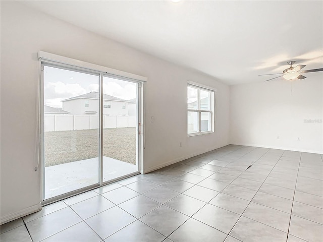 empty room with ceiling fan and light tile patterned floors