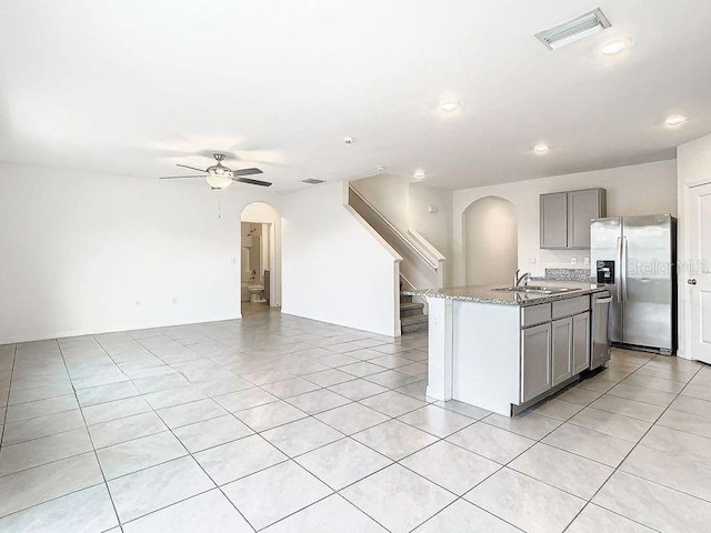 kitchen with sink, ceiling fan, gray cabinets, an island with sink, and stainless steel appliances