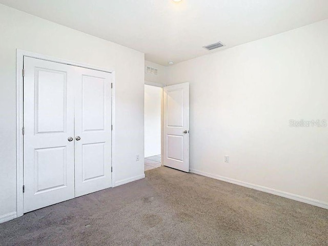 unfurnished bedroom featuring carpet floors and a closet