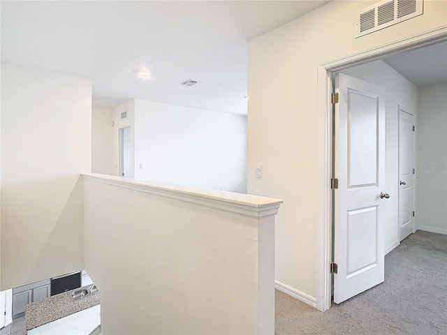 hallway with light colored carpet