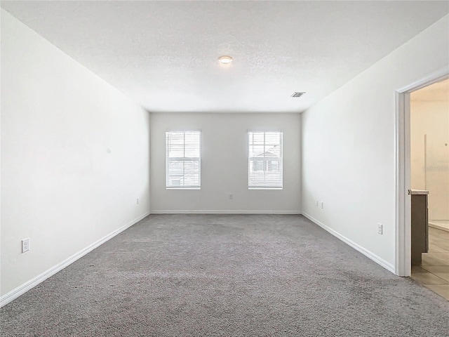 carpeted spare room with a textured ceiling