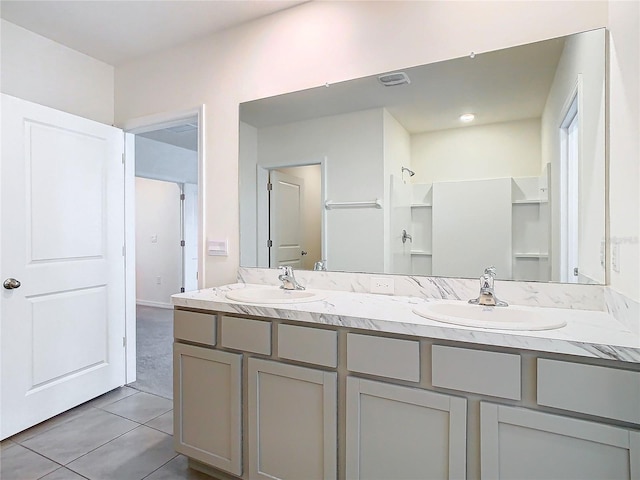 bathroom with a shower, tile patterned flooring, and vanity