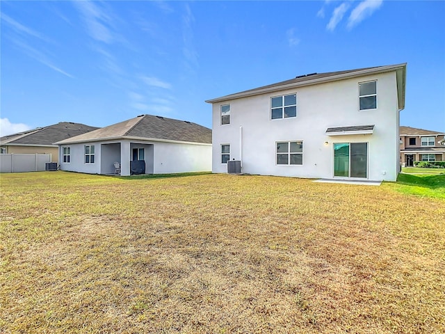 back of house with a yard and central AC