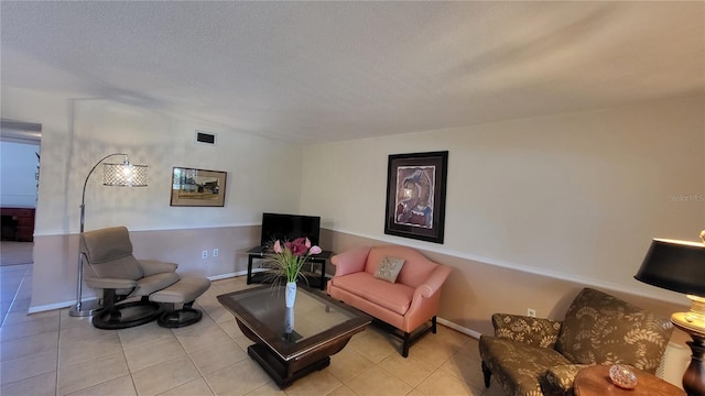 tiled living room featuring a textured ceiling