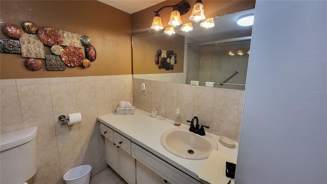 bathroom with toilet, vanity, tile walls, and walk in shower