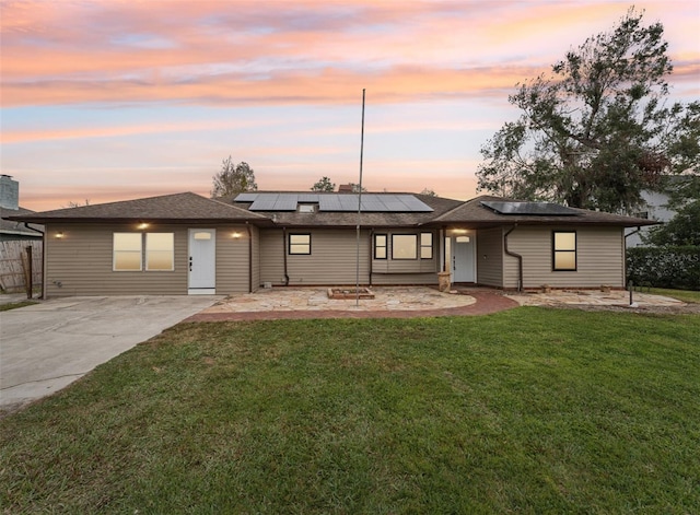 view of front of property with solar panels and a yard