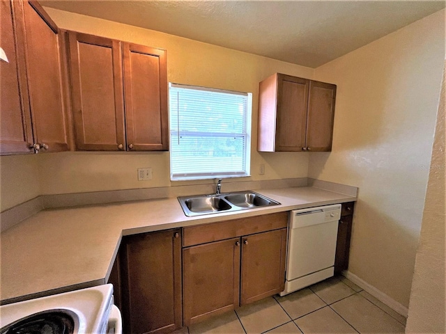 kitchen featuring sink, white dishwasher, stove, and light tile patterned floors