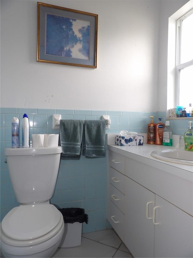 bathroom featuring tile walls, toilet, vanity, and tile patterned flooring