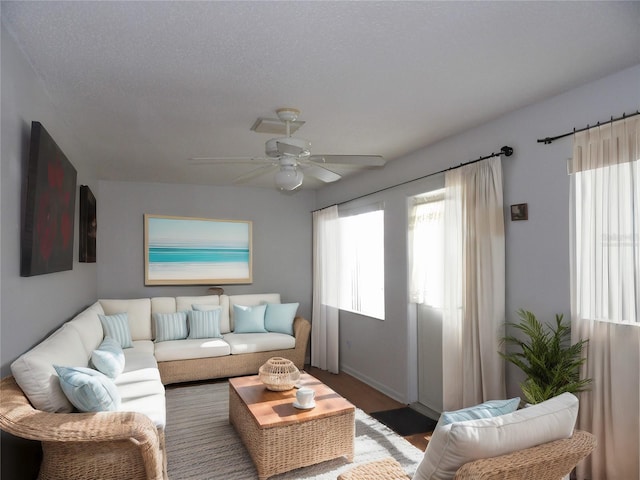 living room with ceiling fan and a textured ceiling