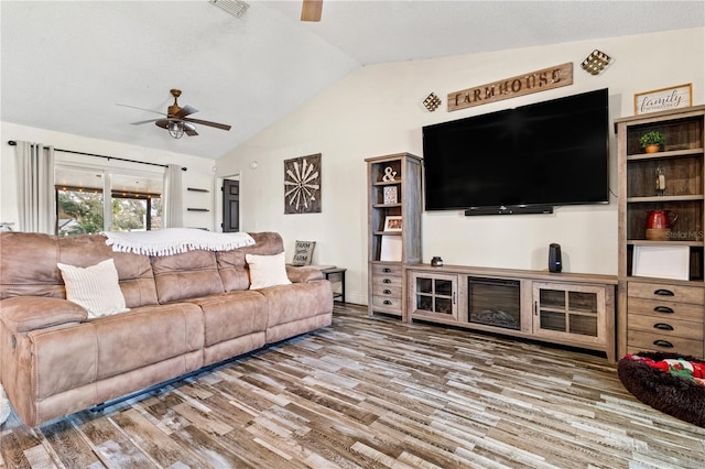 living room with hardwood / wood-style floors, vaulted ceiling, and ceiling fan