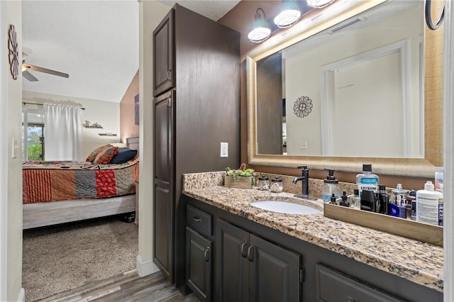 bathroom featuring vanity, wood-type flooring, a textured ceiling, and ceiling fan