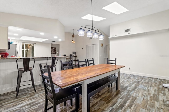 dining area with dark wood-type flooring and a textured ceiling