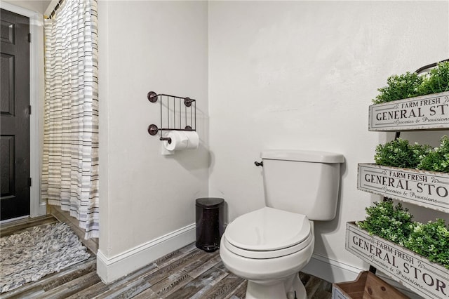 bathroom featuring hardwood / wood-style flooring and toilet