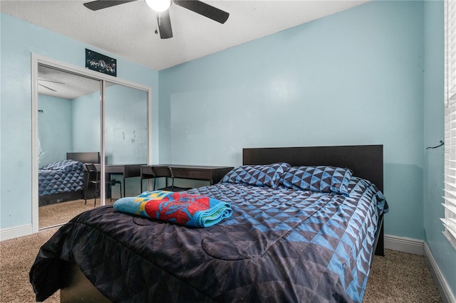 carpeted bedroom with ceiling fan, a closet, and a textured ceiling