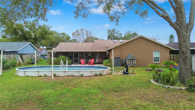 view of pool with a yard and a sunroom