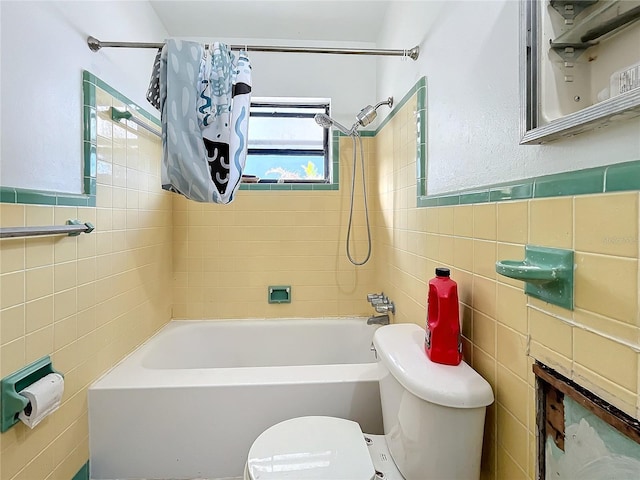 bathroom with shower / tub combo, toilet, and tile walls