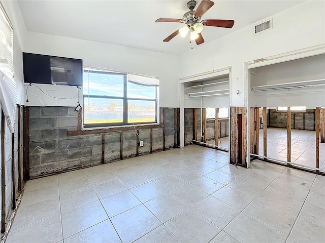 tiled empty room with ceiling fan