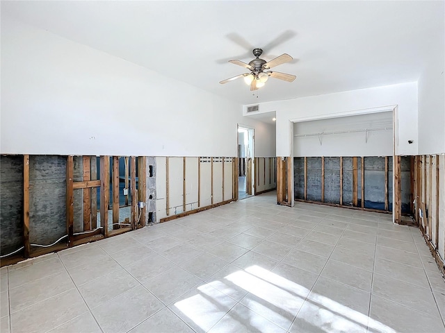 tiled spare room featuring ceiling fan