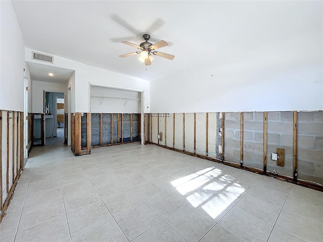 tiled empty room featuring ceiling fan