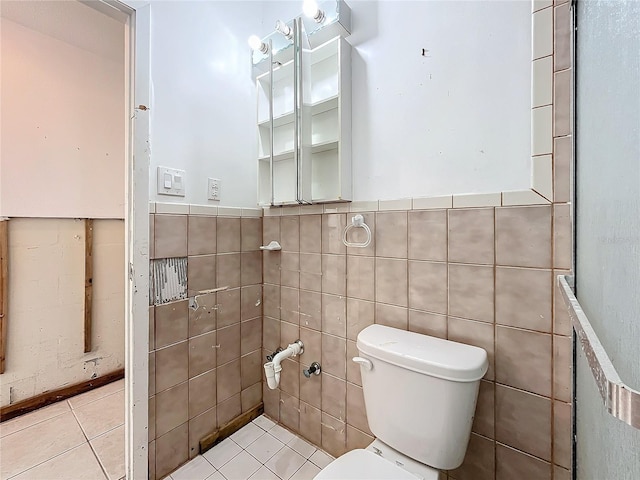 bathroom featuring tile patterned floors, tile walls, and toilet