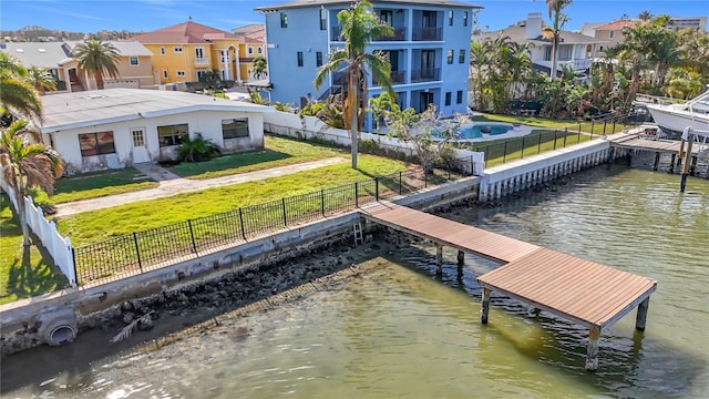 dock area with a water view and a yard