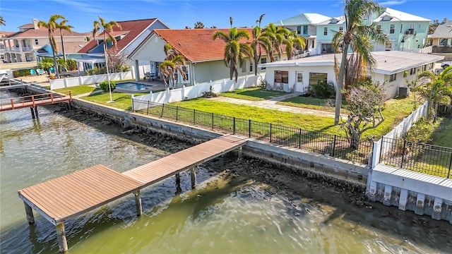 dock area with cooling unit, a yard, and a water view