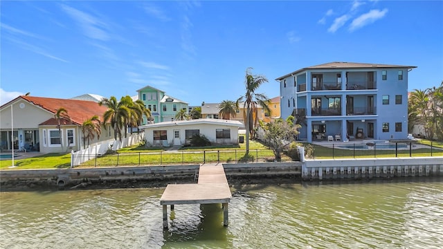 dock area with a water view and a lawn