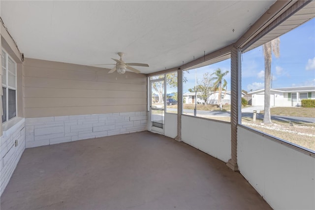 unfurnished sunroom with ceiling fan