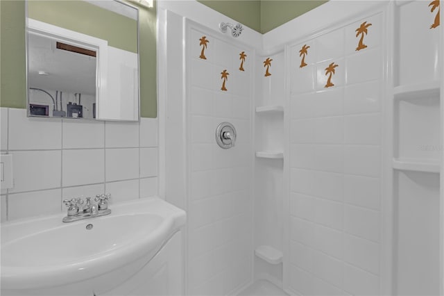 bathroom featuring tile walls, sink, walk in shower, and tasteful backsplash