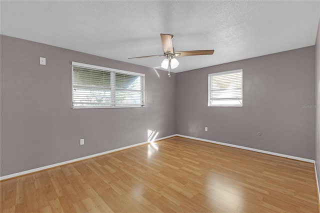 spare room featuring ceiling fan, light hardwood / wood-style flooring, and a textured ceiling