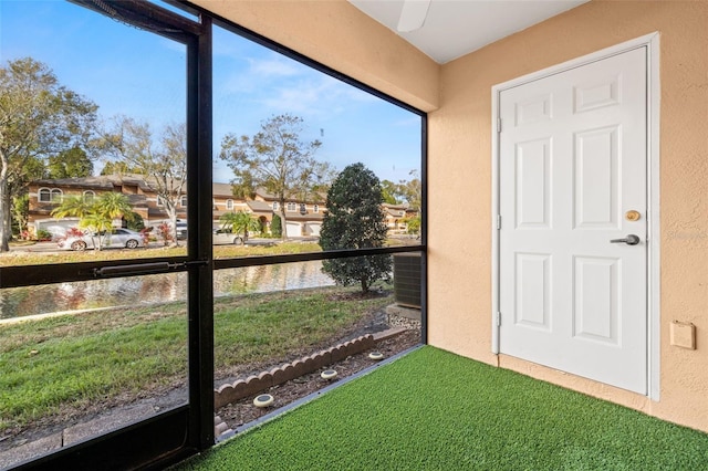 unfurnished sunroom featuring a water view