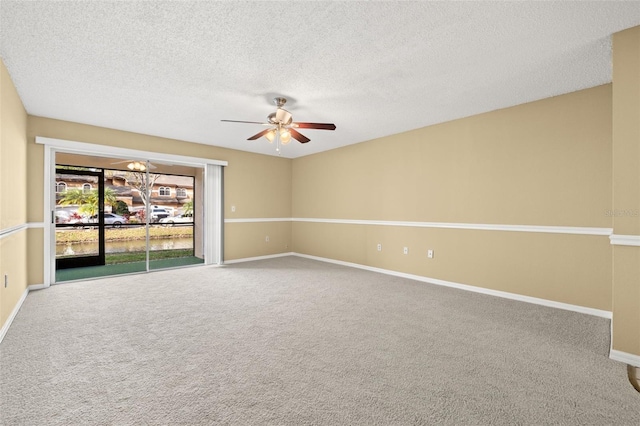 spare room featuring a textured ceiling, carpet floors, and ceiling fan