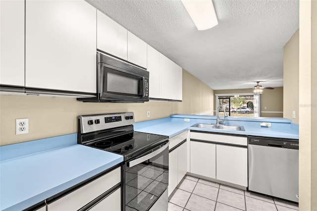 kitchen with white cabinets, sink, ceiling fan, light tile patterned floors, and appliances with stainless steel finishes