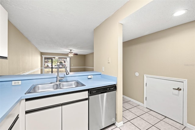 kitchen featuring sink, stainless steel dishwasher, a textured ceiling, light tile patterned flooring, and white cabinetry