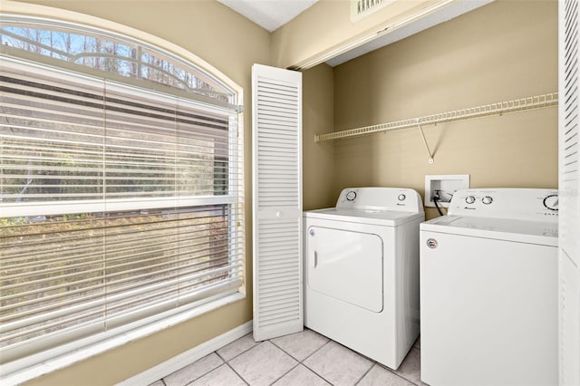 laundry area with light tile patterned floors and washer and clothes dryer