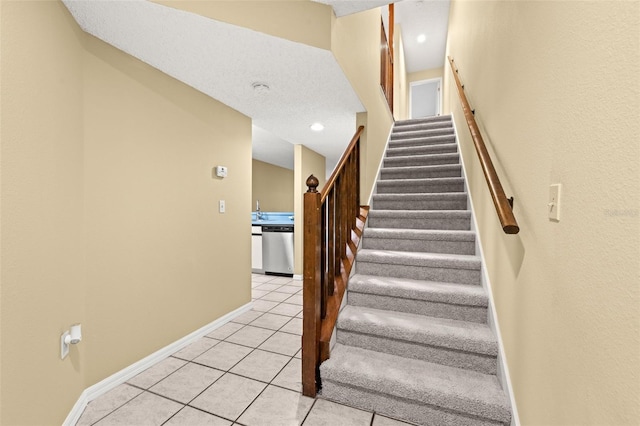 staircase with tile patterned floors and sink