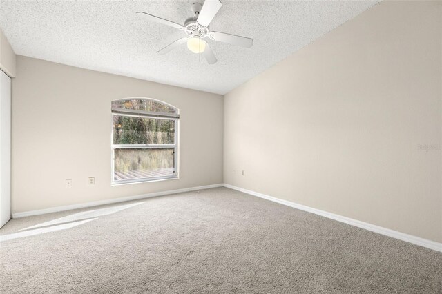 unfurnished room featuring carpet flooring, ceiling fan, and a textured ceiling