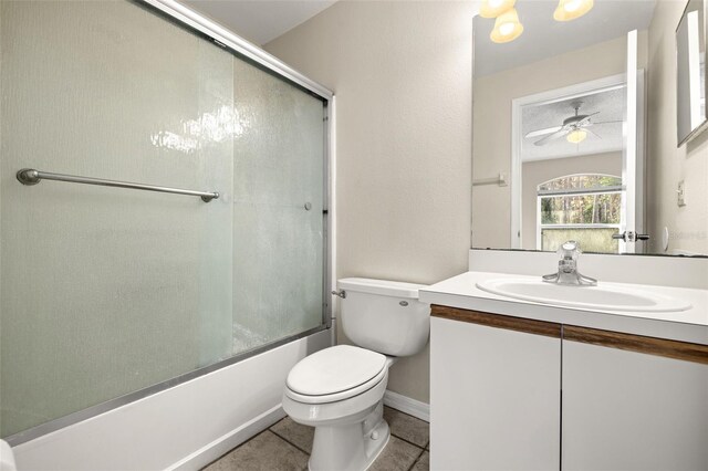 full bathroom with ceiling fan, tile patterned floors, bath / shower combo with glass door, toilet, and vanity