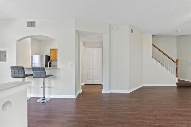 interior space featuring dark wood-type flooring, electric panel, and a textured ceiling