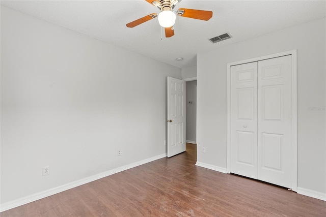 unfurnished bedroom featuring hardwood / wood-style flooring, ceiling fan, and a closet