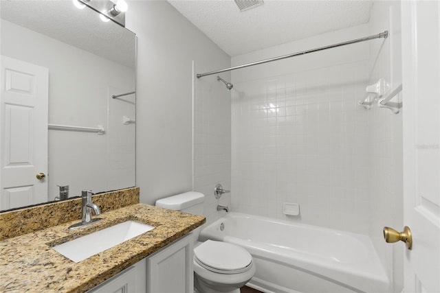 full bathroom featuring vanity, toilet, tiled shower / bath combo, and a textured ceiling