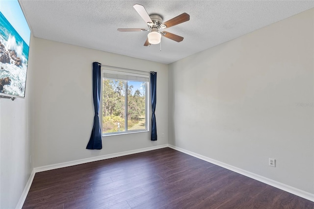 empty room with ceiling fan, dark wood-type flooring, and a textured ceiling